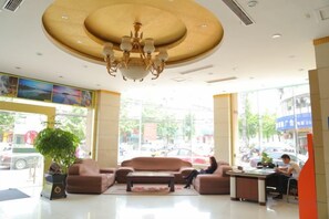 A hotel lobby with a chandelier, seating area, and a receptionist desk. - Laike Yangming Hotel (Chizhou)