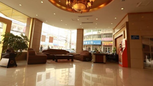 A spacious lobby with a chandelier, seating area, and a large potted plant. - Laike Yangming Hotel (Chizhou)