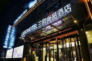 A hotel entrance with illuminated signage, glass doors, and a modern architectural design. - LanOuShangPin Hotel (Shan County Yinzuo Mall) (Shan County)