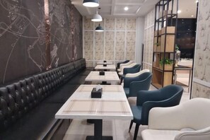 A restaurant interior with a long counter, cushioned seating, and pendant lighting. - LanOuShangPin Hotel (Shan County Central Hospital Yinzuo) (Shan County)