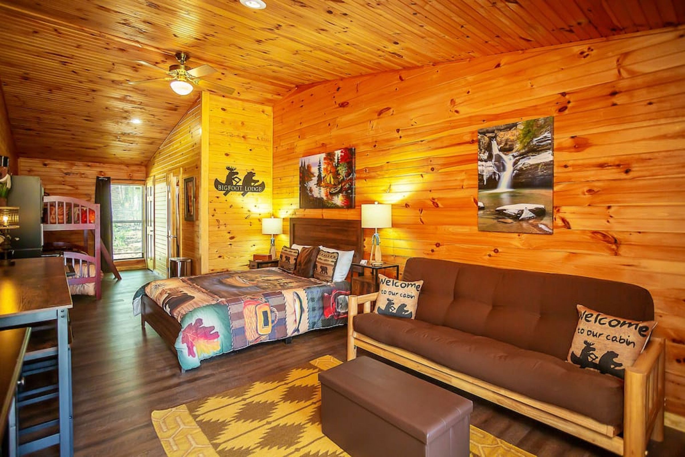 A cabin interior with a bed, sofa, and a dining area.