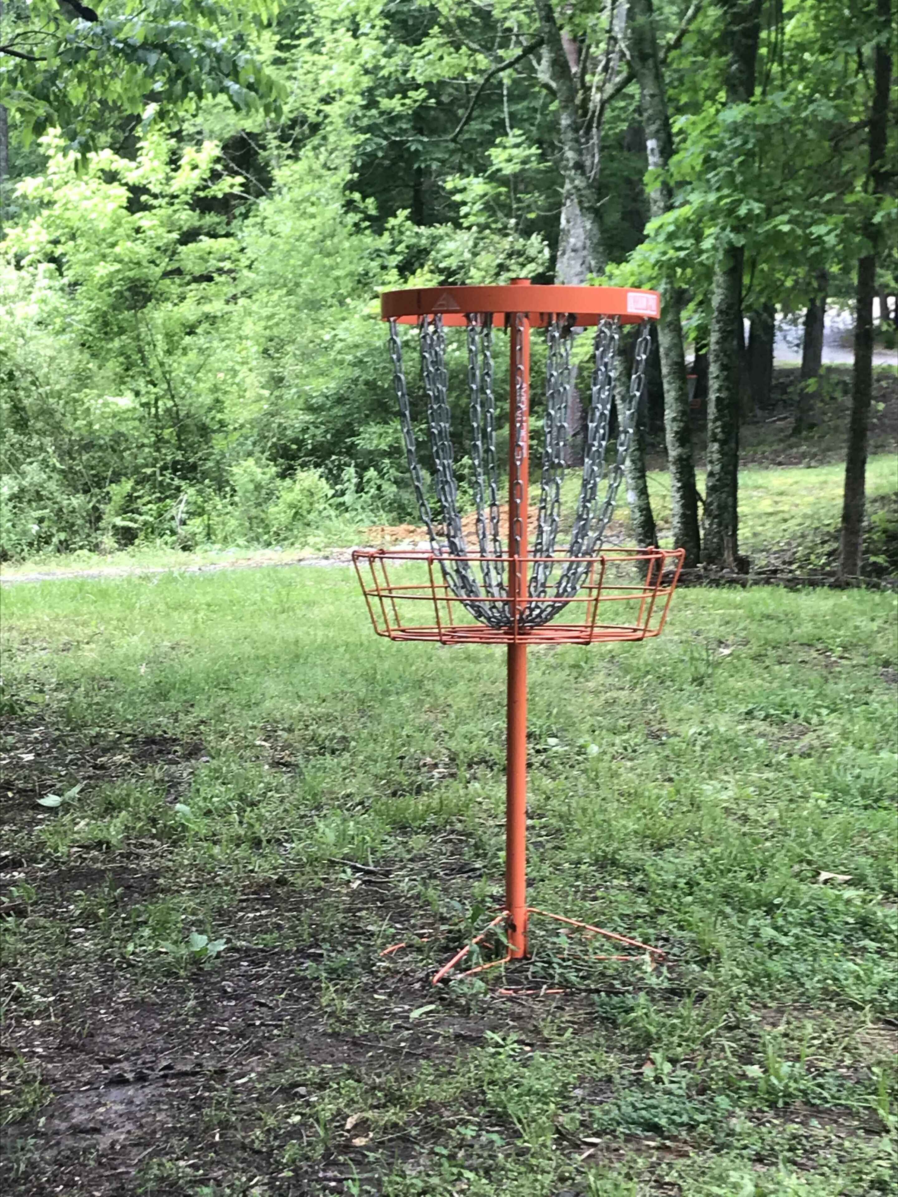 A disc golf basket in a park.