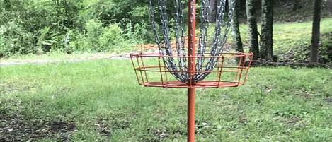 A disc golf basket in a park.