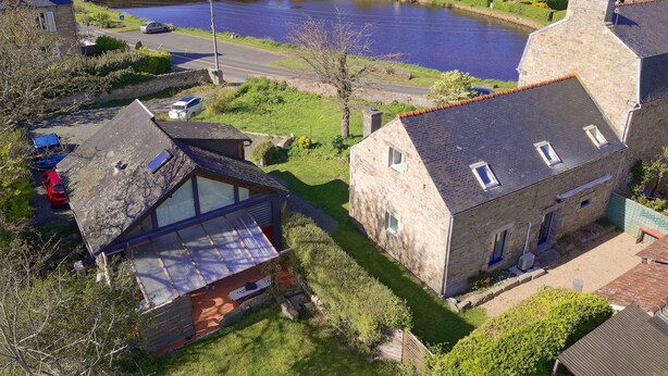 A coastal village with stone buildings, a pond, and a road leading to the sea. - Warm, modern house 50m from the sea (Trébeurden)