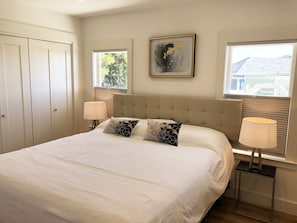 Cozy retreat with a large bed, bedside tables, and a window offering a peaceful atmosphere.