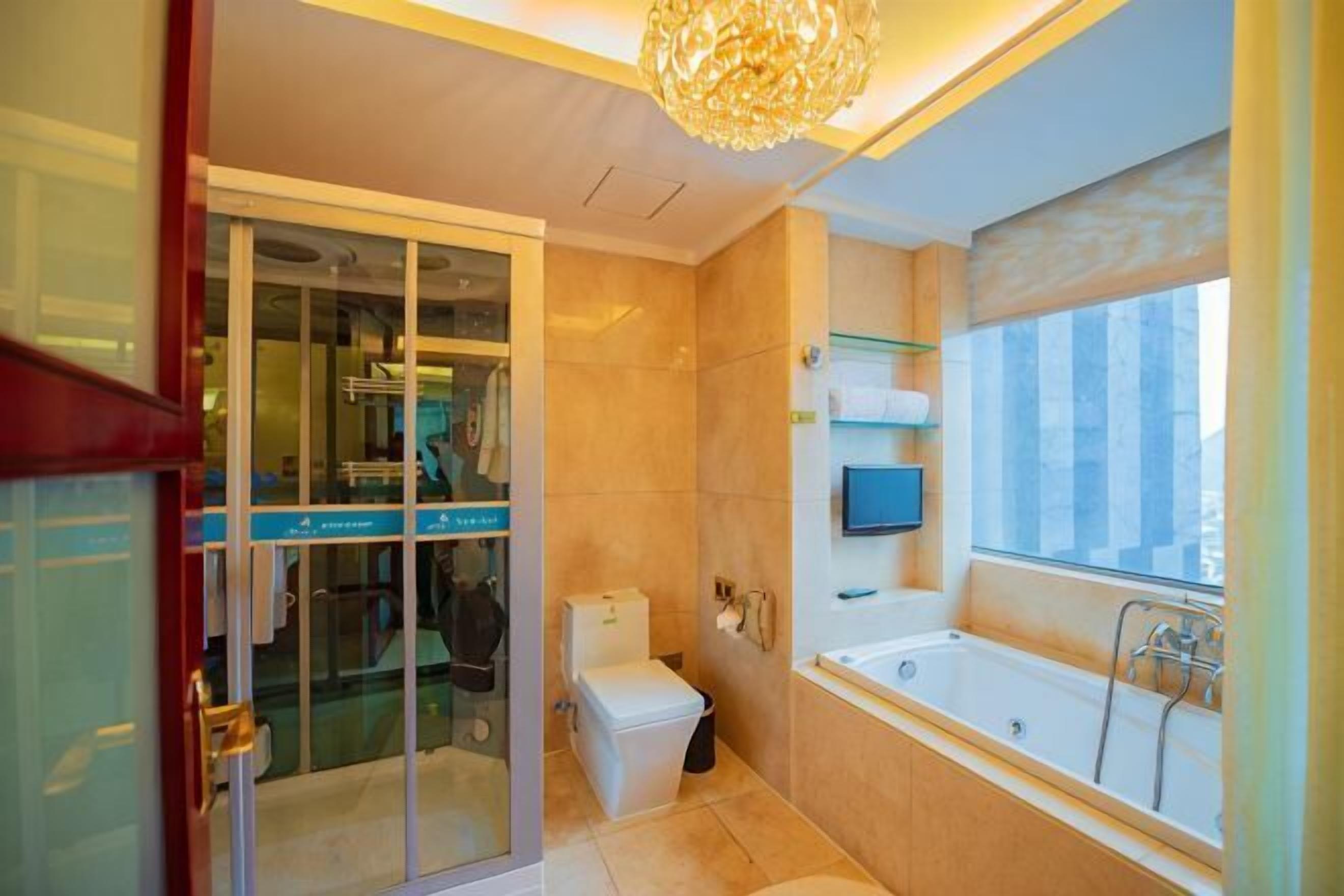 Un baño moderno con cabina de ducha de vidrio, bañera y retrete.