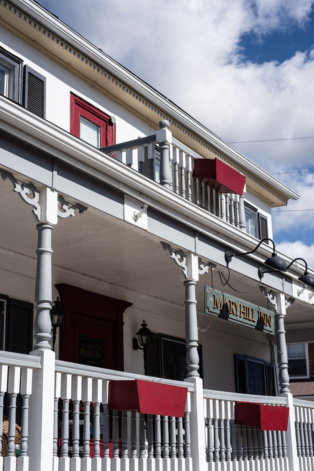 A two-story building with a balcony and a sign that reads "MARYHILL INN".