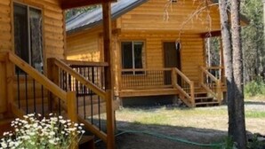 A wooden cabin with a porch and a staircase leading to the entrance. - Treetop Loft-28 miles to Yellowstone-Owner Operated (Island Park)