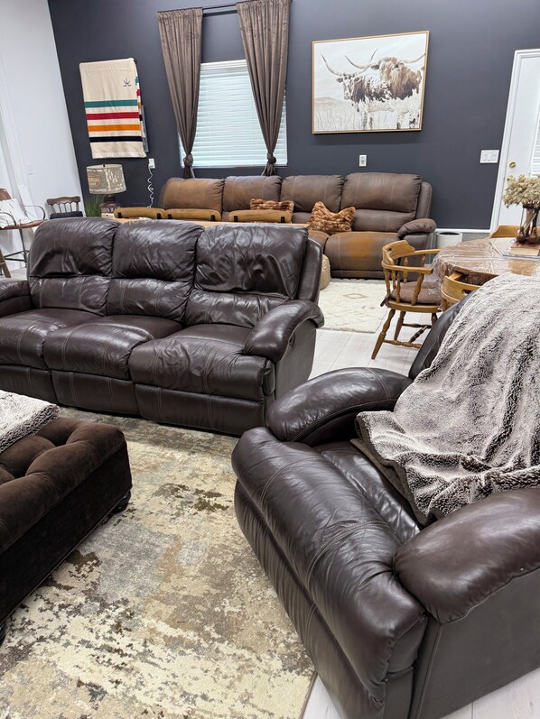 A modern living room with leather sofas, a large rug, and a wall-mounted artwork of a bull. - Cozy, quiet, safe, rustic getaway in West Jordan, Utah with a private hot tub. (West Jordan)