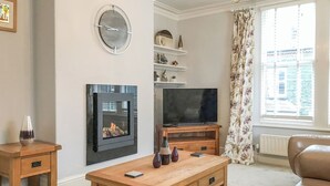 A living room with a fireplace, television, and a sofa.