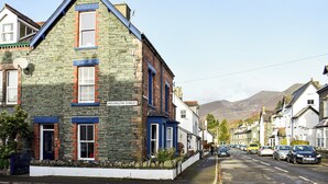 A stone building with a blue roof and a sign reading "Helvellyn Street."