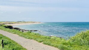 A coastal path with a clear view of the sea and distant buildings. - 2 bedroom accommodation in Alnwick (Alnwick)