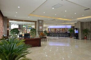 A spacious lobby with a reception desk, seating area, and a large digital screen. - Qin Hai International Hotel (Baiyin)