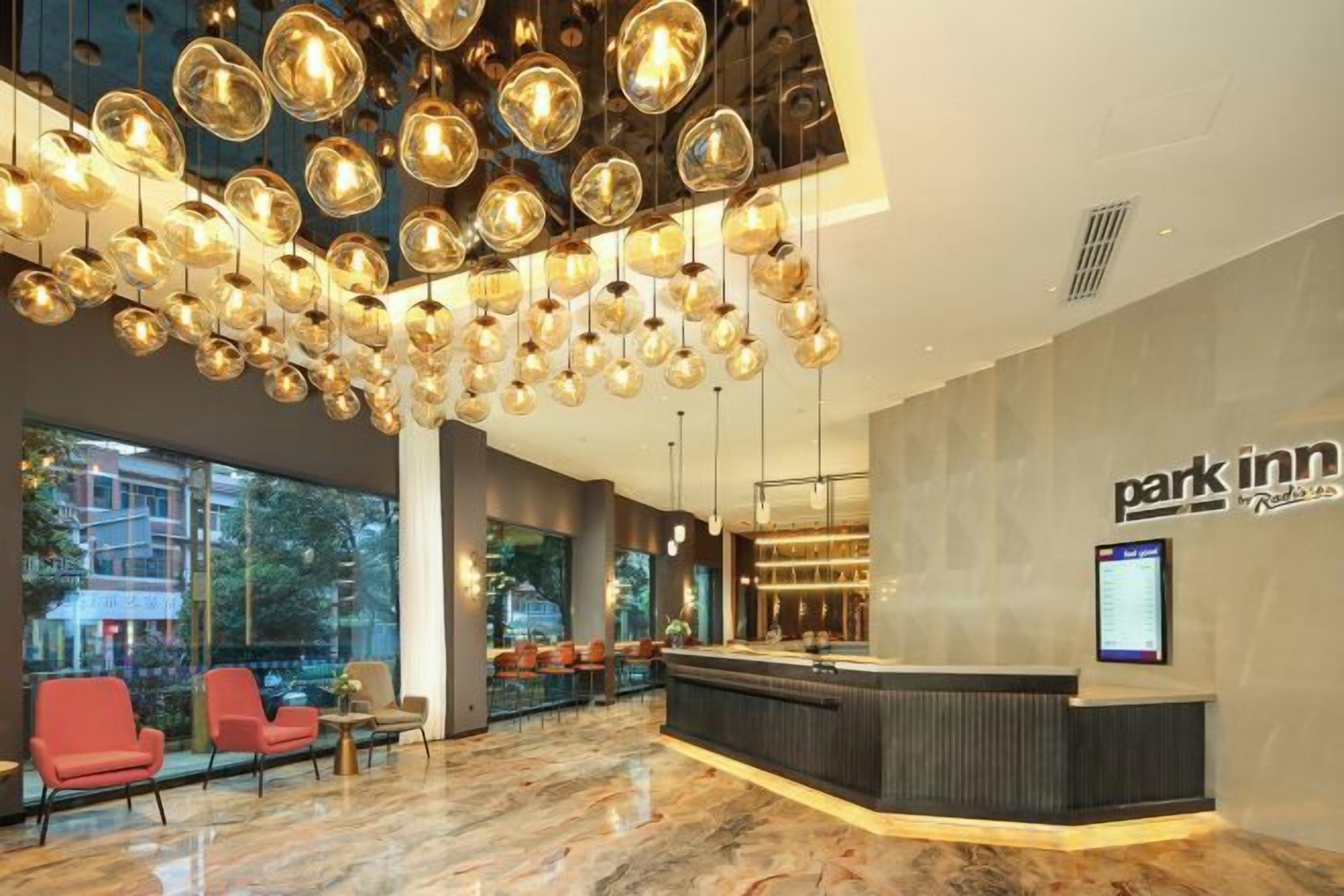 Un hall de hotel con mostrador de recepción, zona de estar y amplios ventanales.