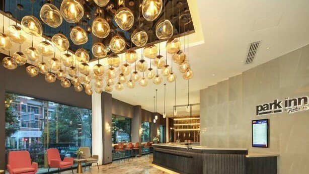 A hotel lobby with a reception desk, seating area, and large windows. - Time Platinum (Ziyun)