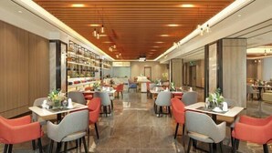 A modern restaurant with a wooden ceiling, red and grey chairs, and a central aisle. - Time Platinum (Ziyun)