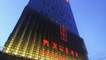 A hotel with a modern facade, featuring a prominent logo and signage in a foreign script.