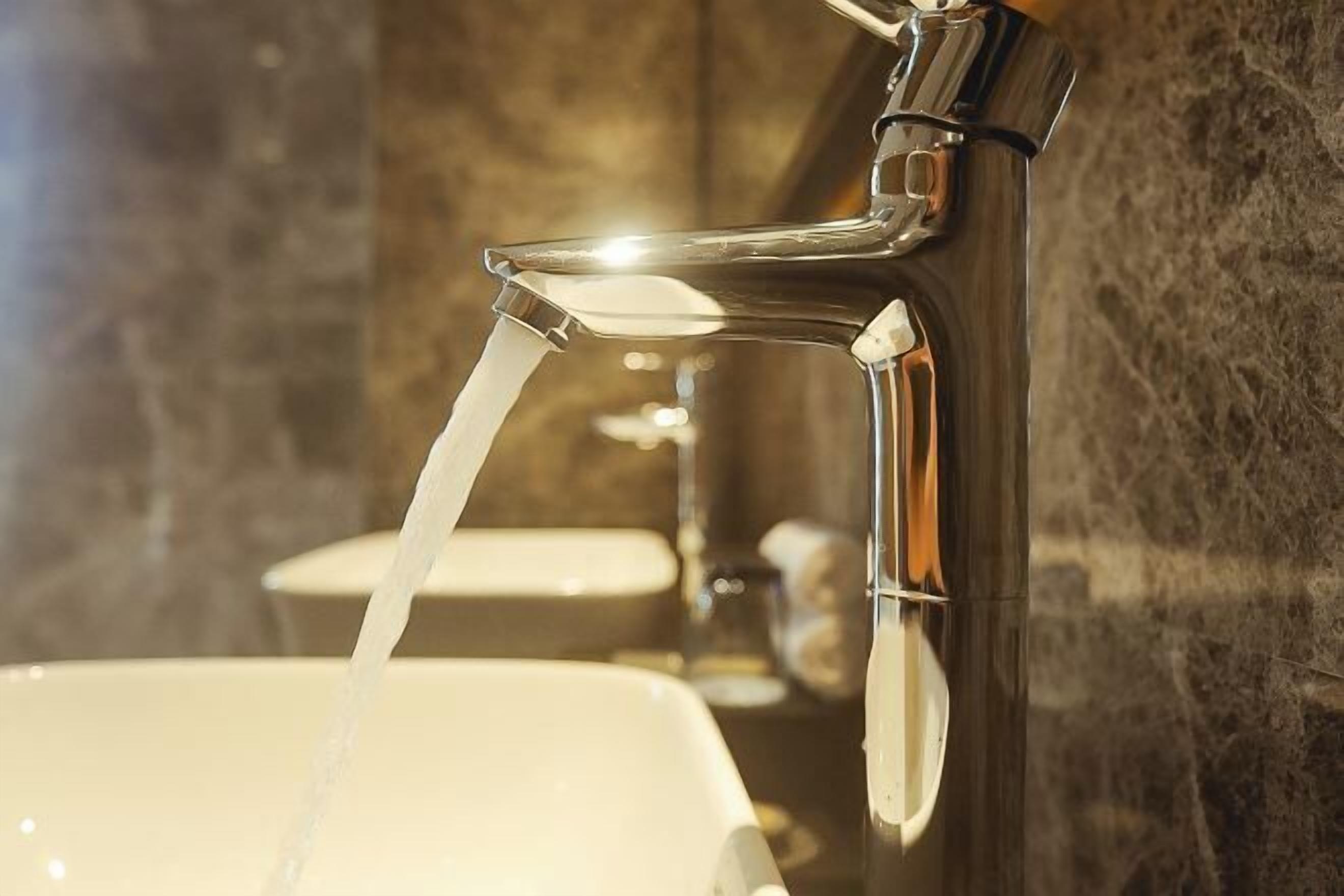 Une salle de bain dotée d'un robinet moderne et d'un lavabo.