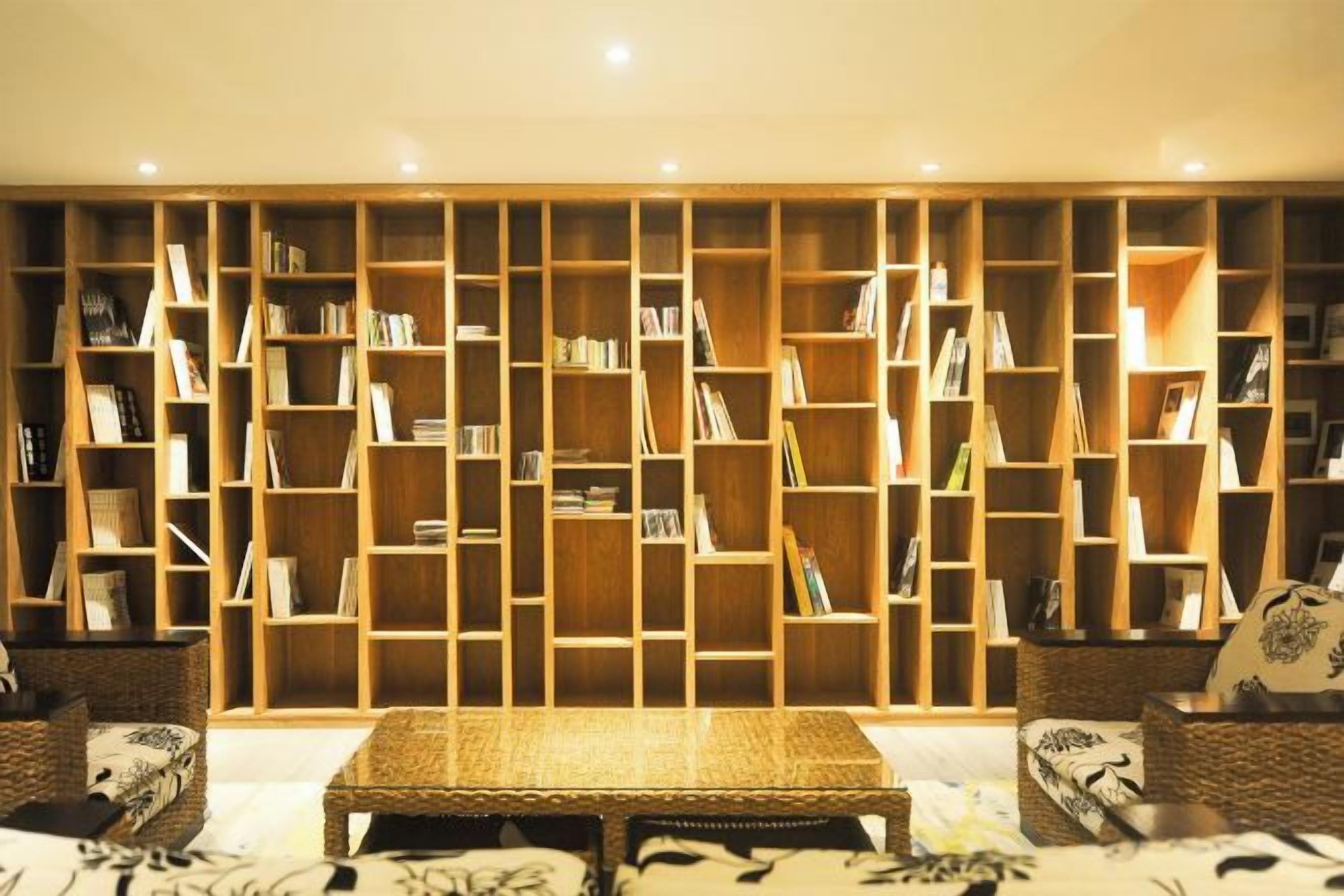 A room with a large bookshelf, a sofa, and a coffee table.