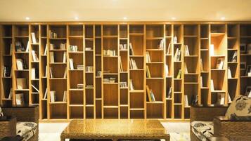 A room with a large bookshelf, a sofa, and a coffee table.