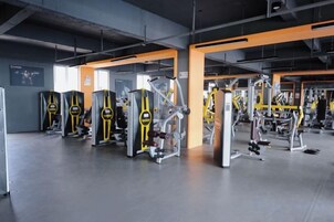 Un gimnasio con diversas máquinas y equipamiento para ejercicio.