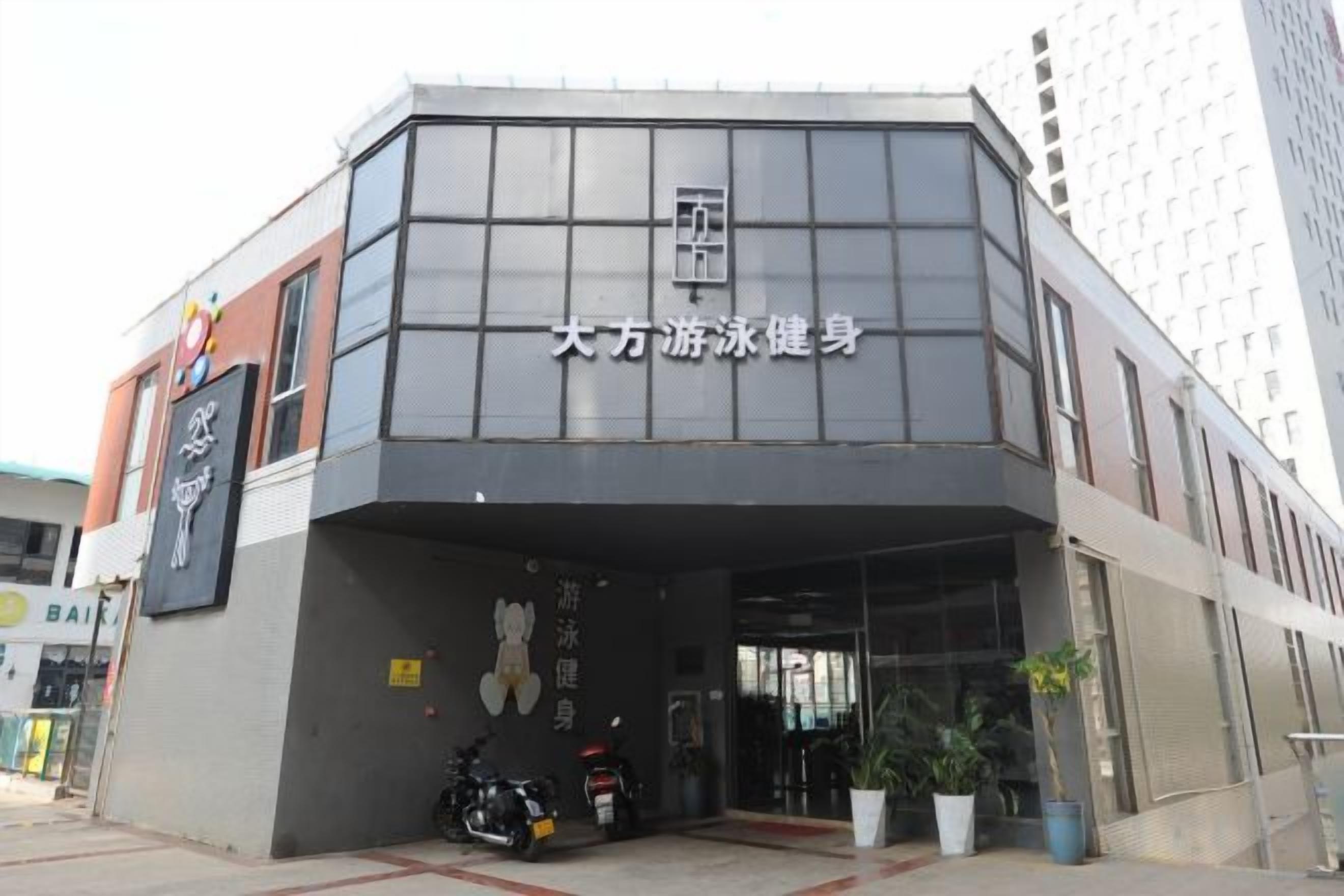 Un edificio con un letrero que dice '大方游泳健身', indicando un centro de salud o de acondicionamiento físico.