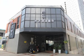 A building with a sign that reads '大方游泳健身' indicating a health or fitness center. - Deepness Hotel (Qiubei)