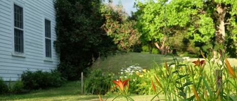 Una casa blanca con un césped y un jardín bien cuidados.