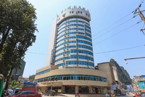 A multi-story hotel with a curved facade, large windows, and a prominent entrance. - Rongshui Miaoshan International Hotel (Liuzhou)