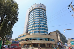 A multi-story hotel with a curved facade, large windows, and a prominent entrance.