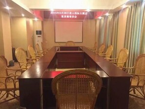 A conference room with a long table, chairs, a projector screen, and a wall-mounted air conditioning unit. - Rongshui Miaoshan International Hotel (Liuzhou)