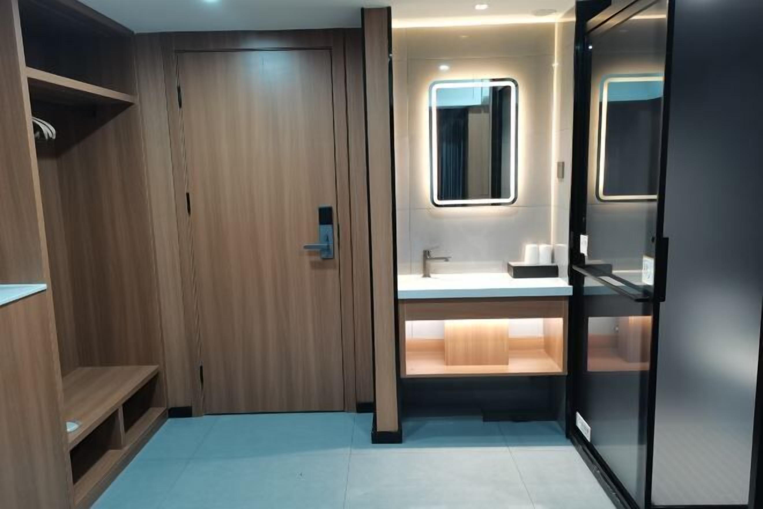 A modern bathroom with a wooden vanity, a mirror, and a built-in sink.