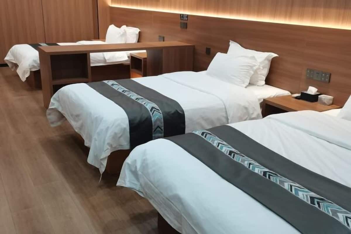 Una habitación de hotel con dos camas, un escritorio y una mesita de noche.