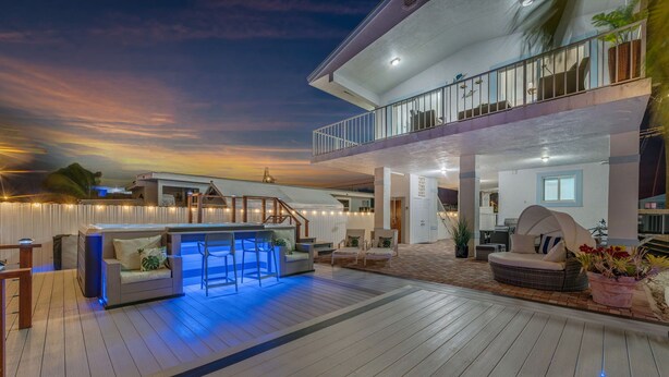 A spacious outdoor deck with a hot tub, seating areas, and a covered patio. - Luxury 4B/3B, Private Canal, Kayaks, 13 ft Hot Tub, 4 H Mini-Golf & Pedal Boat. (Tavernier)