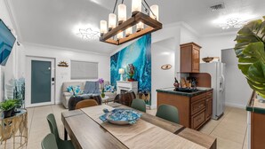 A modern kitchen with a wooden table, chairs, and a dining area. - Luxury 4B/3B, Private Canal, Kayaks, 13 ft Hot Tub, 4 H Mini-Golf & Pedal Boat. (Tavernier)
