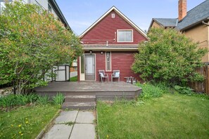 A red house with a small porch and two chairs.