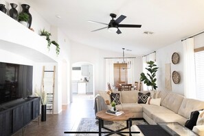Relax in this stylish living room with a large flat-screen TV, plush sofa, and cozy coffee table.