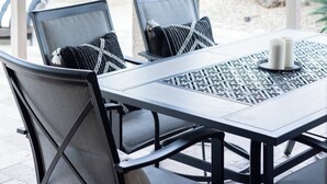 An outdoor patio with a table and chairs, a ceiling fan, and a view of the garden. - The Gilbert Haven - comfortable, stylish w/ pool (Gilbert)