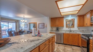A kitchen with wooden cabinets, granite countertops, a dishwasher, and a stove. - Interlaken #19 - 3 Bedroom 3 Bathroom Unit (June Lake)