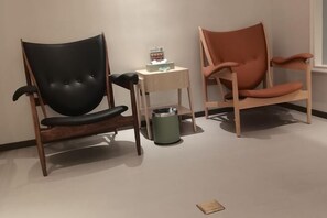 Two chairs, one black and one orange, next to a small table with a tissue box. - Dongfang Yijing Hotel (Jinyun)