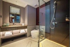 A modern bathroom with a glass-enclosed shower, a vanity with a mirror, and a toilet. - Dongfang Yijing Hotel (Jinyun)