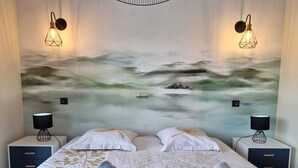 A hotel room with a bed, two bedside tables with lamps, and a large abstract painting on the wall. - Porto Vecchio villa with heated pool near San Ciprianu beach (Porto Vecchio)