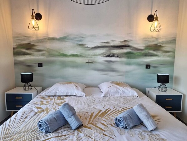 A hotel room with a bed, two bedside tables with lamps, and a large abstract painting on the wall.