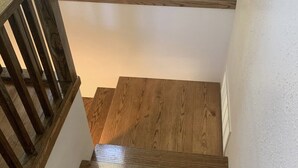 A wooden staircase with a handrail and a white wall. - 4 bedrooms 3 bath, Tranquil Home, Master suite & Jet tub, Mins from Hot Springs (Thermopolis)