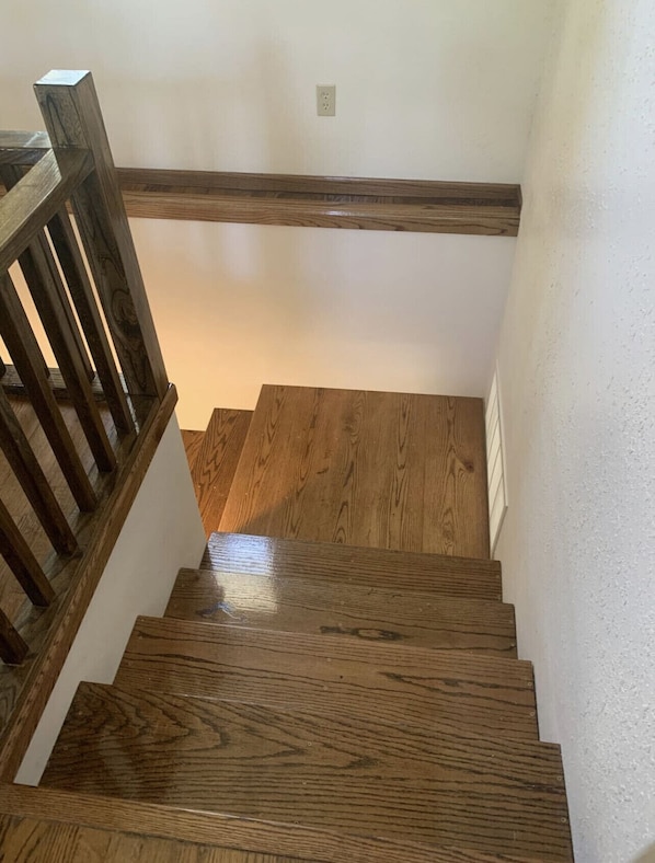 A wooden staircase with a handrail and a white wall. - 4 bedrooms 3 bath, Tranquil Home, Master suite & Jet tub, Mins from Hot Springs (Thermopolis)