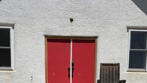 A wooden deck leading to a red door with a chair beside it. - 4 bedrooms 3 bath, Tranquil Home, Master suite & Jet tub, Mins from Hot Springs (Thermopolis)