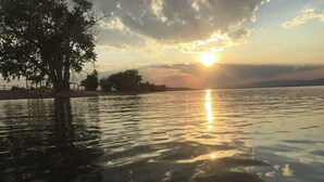 A sunset over a calm body of water with a tree on the left and a distant shoreline. - 4 bedrooms 3 bath, Tranquil Home, Master suite & Jet tub, Mins from Hot Springs (Thermopolis)