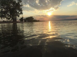 A sunset over a calm body of water with a tree on the left and a distant shoreline. - 4 bedrooms 3 bath, Tranquil Home, Master suite & Jet tub, Mins from Hot Springs (Thermopolis)