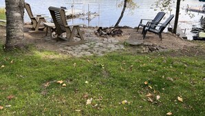 A lakeside deck with Adirondack chairs, a covered picnic table, and a stone pathway. - Big Sandy Lake.  Beautiful and Private!<br><br> (McGregor)