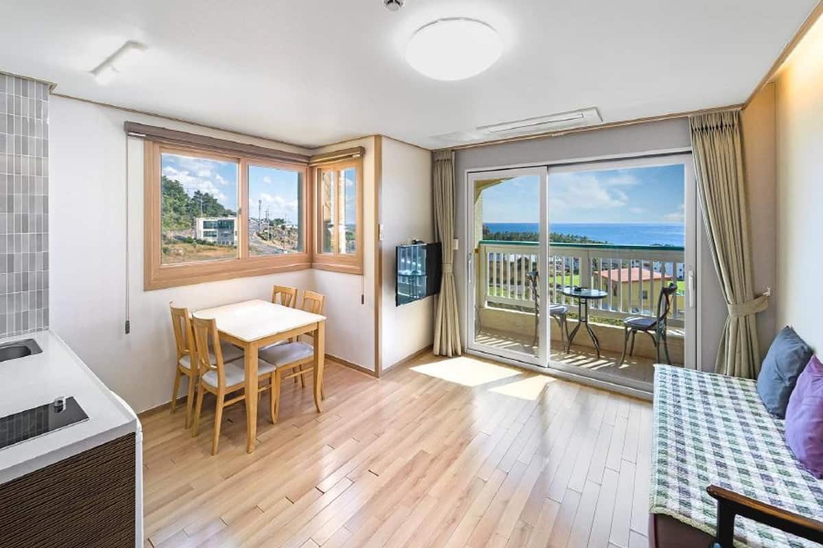 Une chambre moderne avec un coin repas, un canapé et un balcon offrant une vue agréable.